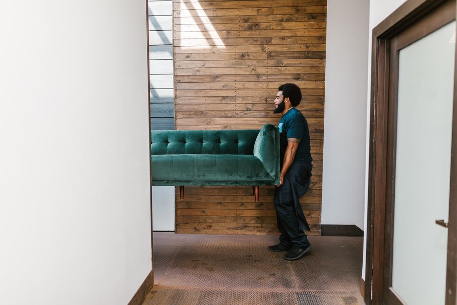 Movers safely carrying heavy furniture